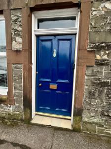 a blue door on the side of a building at The Blue Door in Kirkcudbright