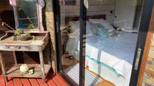 a glass window of a bedroom with a bed at Cabaña del Bosque in Pichilemu