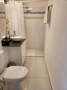 a white bathroom with a toilet and a sink at Hello-Guyane, Marina 2, Studio Prestige 5 étoiles in Saint-Laurent du Maroni
