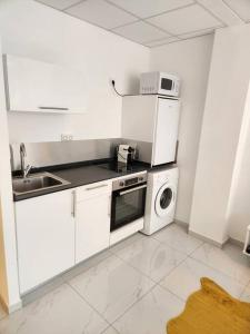a white kitchen with a sink and a microwave at Hello-Guyane, Marina 2, Studio Prestige 5 étoiles in Saint-Laurent du Maroni +20 photos