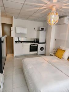 una cocina blanca con una cama grande en una habitación en Hello-Guyane, Marina 2, Studio Prestige 5 étoiles, en Saint-Laurent-du-Maroni