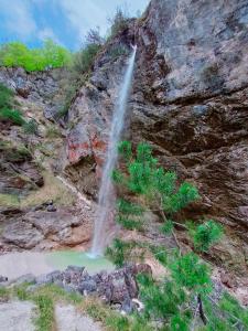 a waterfall on the side of a rocky mountain at Apartma Metka Bovec in Bovec