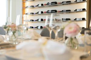 a table with glasses on a shelf with wine bottles at Hotel & Restaurant Nollen in Hosenruck