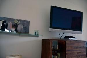 a flat screen tv sitting on top of a wooden entertainment center at Rosenalm - Appartement 30 in Scheidegg
