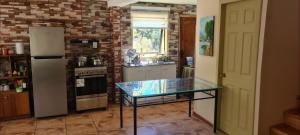 a kitchen with a refrigerator and a glass table in it at Casa Selva in Valdivia +14 photos