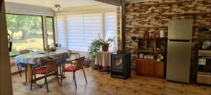 a kitchen with a table with chairs and a refrigerator at Casa Selva in Valdivia