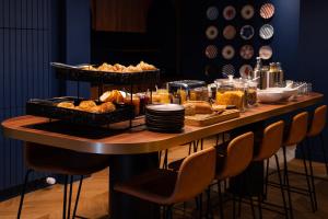 una mesa con pan y cestas de comida. en Hôtel D'Anjou, en Angers
