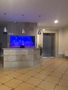 Un vestíbulo vacío con un gran acuario azul en el centro. en Apartament Rezydencja Przy Młynie, en Gorzów Wielkopolski