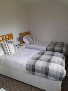 dos camas sentadas una al lado de la otra en un dormitorio en Lealt Falls House en Culnacnoc