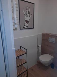 a bathroom with a toilet and a picture on the wall at Graniczna 8a in Bydgoszcz