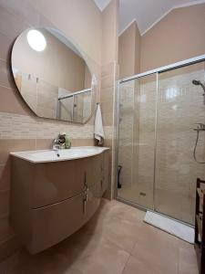 La salle de bains est pourvue d'un lavabo et d'une douche avec un miroir. dans l'établissement Apartments Four You, à Zadar