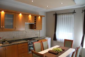 cocina con mesa y fogones horno superior en Németh Apartman Sárvár, en Sárvár