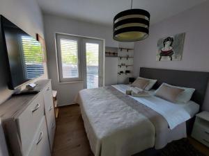 sypialnia z dużym łóżkiem i telewizorem w obiekcie Anago Apartments w mieście Zadar