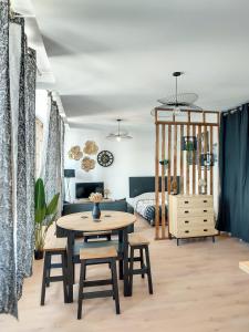 uma sala de estar com uma mesa e um sofá em Magnifique studio hyper centre gare 2pers wifi em Saint-Quentin