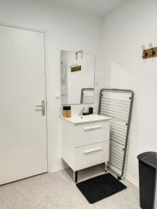 uma casa de banho branca com um lavatório e um espelho em Magnifique studio hyper centre gare 2pers wifi em Saint-Quentin