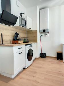 uma cozinha com uma máquina de lavar roupa e um micro-ondas em Magnifique studio hyper centre gare 2pers wifi em Saint-Quentin