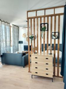 uma sala de estar com um sofá azul e uma cómoda em Magnifique studio hyper centre gare 2pers wifi em Saint-Quentin