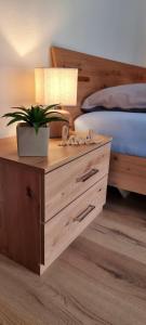 a wooden nightstand with a plant on it next to a bed at Apartma Metka Bovec in Bovec