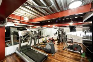 - une salle de sport avec tapis de course et vélos elliptiques dans l'établissement Cozy & Vibrant Loft with Rooftop & Gym in Polanco, à Mexico