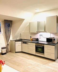 a large kitchen with white cabinets and appliances at Sweet Home Appartements in Bottrop