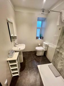 a white bathroom with a sink and a toilet at The Blue Door in Kirkcudbright