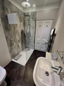 a bathroom with a shower and a sink and a toilet at The Blue Door in Kirkcudbright +31 photos