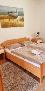 a bed in a bedroom with a painting on the wall at Apartma Metka Bovec in Bovec