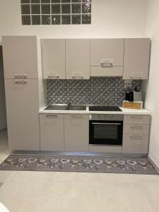 a kitchen with white cabinets and a stove top oven at Casa Don Saro in Giardini Naxos +25 photos