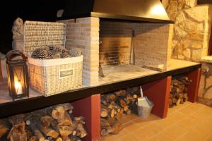 a brick fireplace with baskets and logs on a shelf at Casa el Escalerón in Uña