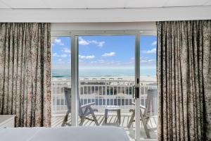 a bedroom with a view of the ocean from a balcony at Montreal Beach Resort in Cape May