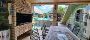 a patio with a table and a brick fireplace at Recanto Dumar in Peruíbe