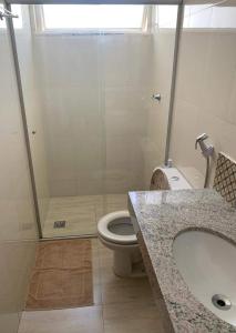 a bathroom with a toilet and a sink and a shower at Apartamento Aconchegante SETOR OESTE in Goiânia