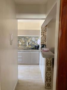 a kitchen with a counter in the middle of a room at Apartamento Aconchegante SETOR OESTE in Goiânia