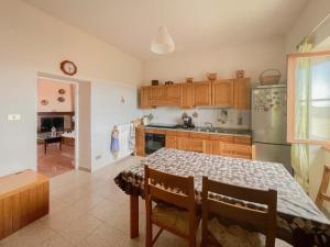 a kitchen with a table and a refrigerator at Villa in campagna tra natura e verde in Montalto di Castro