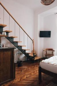 ein Wohnzimmer mit einer Treppe und einem Bett in der Unterkunft Vista Studio Brasov in the Heart of the Old City Center in Braşov