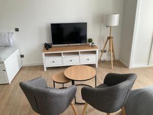 een woonkamer met een tv en een tafel en stoelen bij San Vicente 6, 2ºA Vigo in Vigo