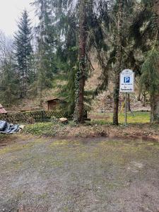 a sign for a parking lot next to a tree at Pension zur Hammermühle in Wallenfels