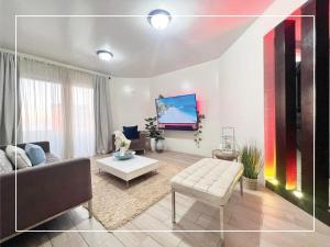 sala de estar con sofá y TV en Condominio completo con vista al mar, en Tijuana