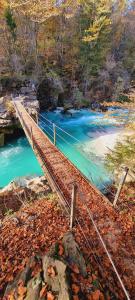 a wooden bridge over a river with blue water at Apartma Metka Bovec in Bovec
