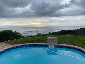 a swimming pool with a view of the ocean at La Vue in Port Shepstone