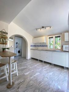 une grande cuisine avec des placards blancs et une table dans l'établissement Denia's Beach House - Colibri, à Dénia