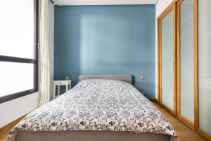 Ce lit se trouve dans un dortoir doté d'un mur bleu. dans l'établissement Luxury apartment Anfaplace, close to the beach, à Casablanca