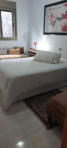 サンタクルス・デ・テネリフェにあるCozy room near Las Teresitas beachの窓付きの客室で、白い大型ベッド1台が備わります。