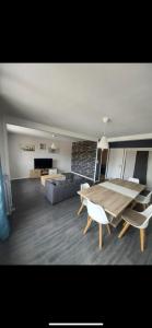 uma sala de estar com uma mesa e um sofá em Appart lumineux au calme 2 ou 3 pers em Chalon-sur-Saône