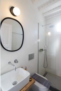 y baño con lavabo blanco y espejo. en MYKONOS HOUSE Eternity maisonette , Mykonos Town en Mykonos