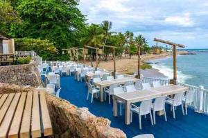 una fila de mesas y sillas en una playa en Habitación cerca del Mar, Obelisco Macho y Zona Colonial, en Santo Domingo