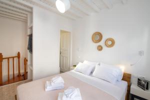 1 dormitorio con 1 cama con sábanas blancas y toallas en MYKONOS HOUSE Eternity maisonette , Mykonos Town en Mykonos