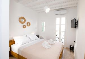 1 dormitorio blanco con 1 cama y TV en MYKONOS HOUSE Eternity maisonette , Mykonos Town en Mykonos