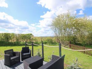 a deck with chairs and a fence and a field at Cherry Pod 2 in Shrewsbury