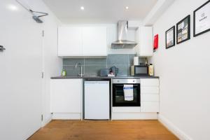 a kitchen with white cabinets and a stove at Central Buckingham Apartment #1 with Free Parking, Pool Table, Fast Wifi and Smart TV with Netflix by Yoko Property in Buckingham